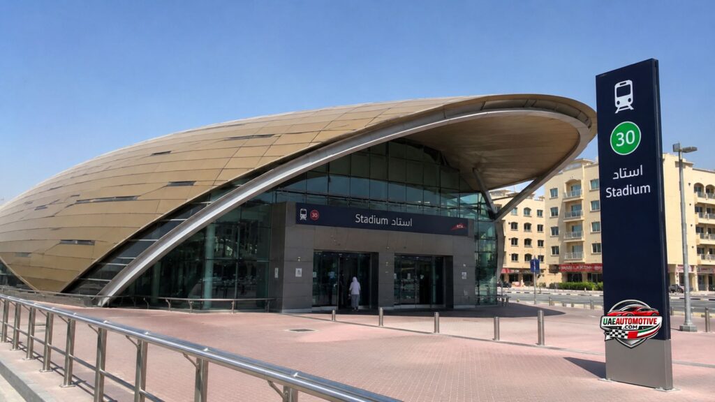 Realistic wide-angle view of Stadium Metro Station 1 Dubai with a modern Dubai Metro train at the platform, clean station architecture, passengers walking, and bright daytime lighting in a 16:9 format.