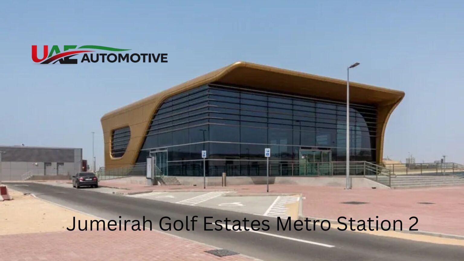Jumeirah Golf Estates Metro Station 2 Jumeirah Golf Estates Metro Station 2 exterior in Dubai featuring a modern curved architectural design with a glass façade, roadside access, and clear blue sky.