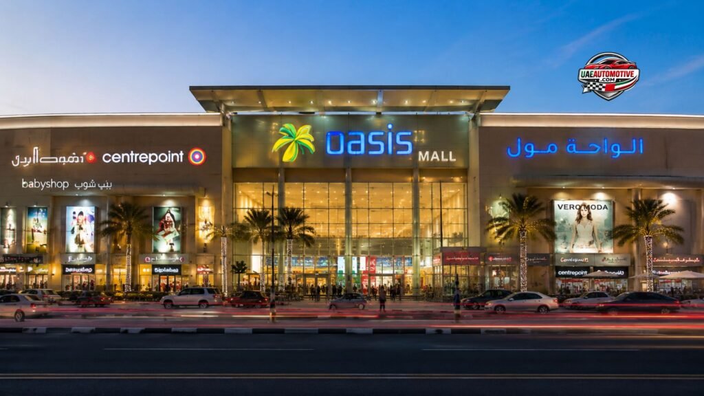 Front view of Oasis Mall Dubai at dusk featuring the illuminated entrance, palm-lined façade, Centrepoint store, busy Sheikh Zayed Road traffic, and visitors entering the shopping mall.