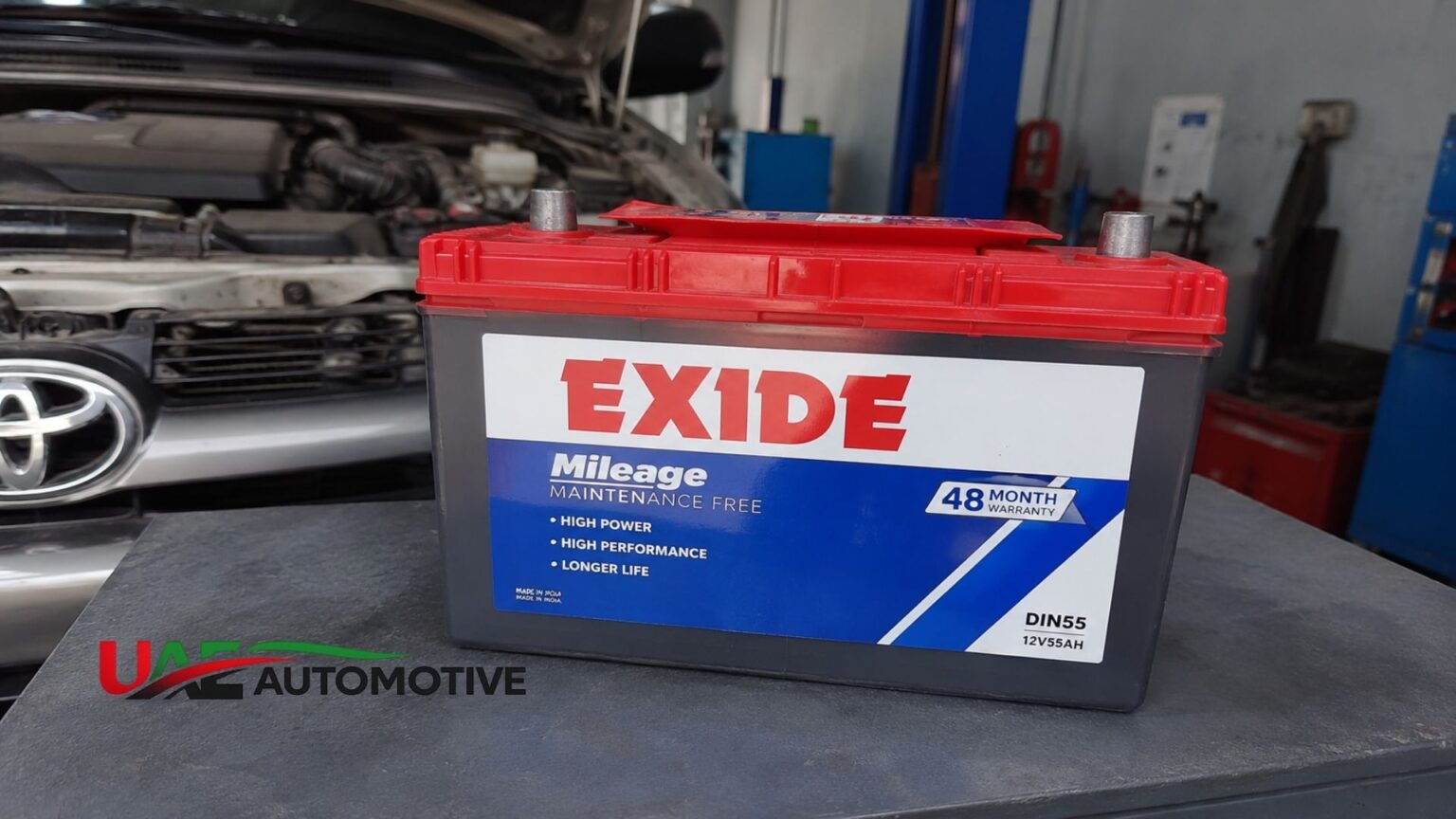 Exide Car Battery Price in UAE: Complete Cost Guide Exide car battery placed on a workshop table with a vehicle under maintenance in the background.