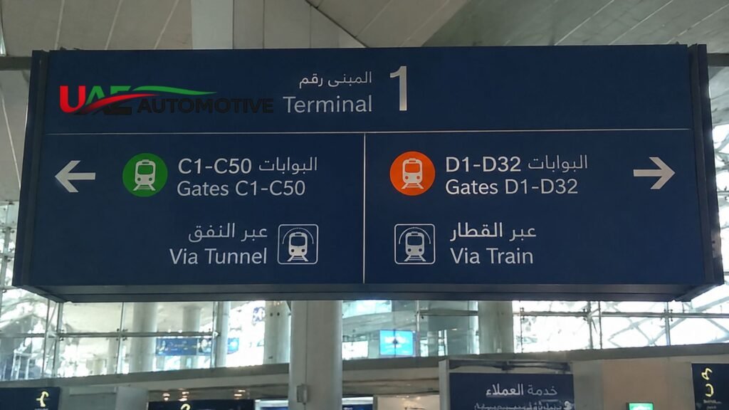 Overhead directional sign inside Dubai Airport Terminal 1 showing access to Concourse C via tunnel and Concourse D via train.